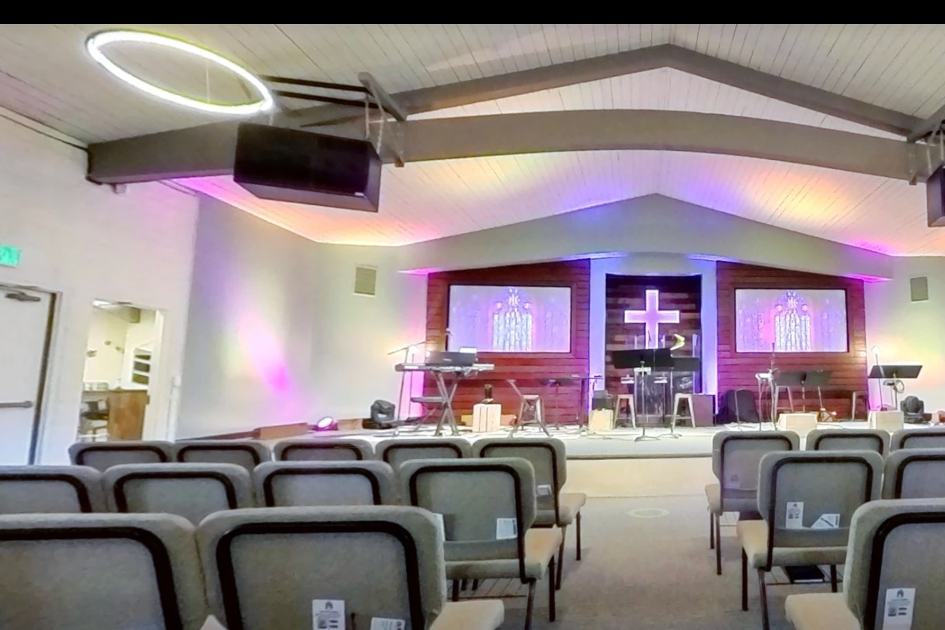Agoura Bible Fellowship sanctuary before the upgrade, with the stage, cross and screens under the arched ceiling