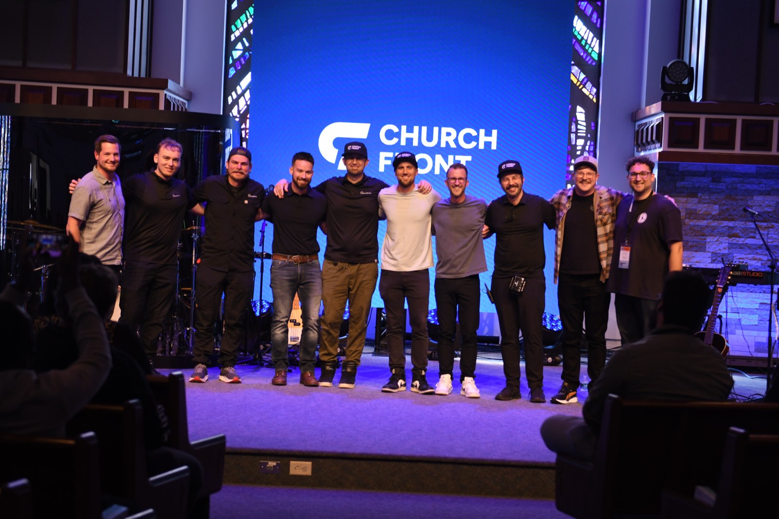 The Churchfront team arm in arm on stage at the Churchfront Conference