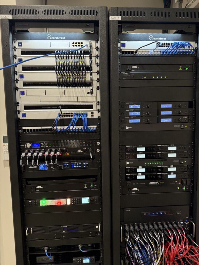 Two finished church AV equipment racks with network switches, labeled patch panels and dressed patch cables
