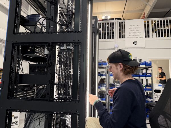 A Churchfront tech wiring an equipment rack in the Churchfront warehouse