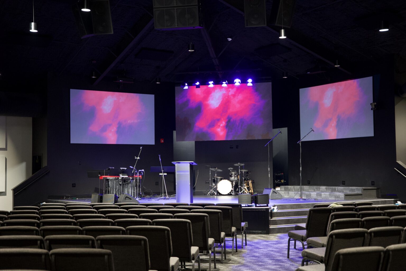 Church worship room with a center LED wall flanked by two projection screens