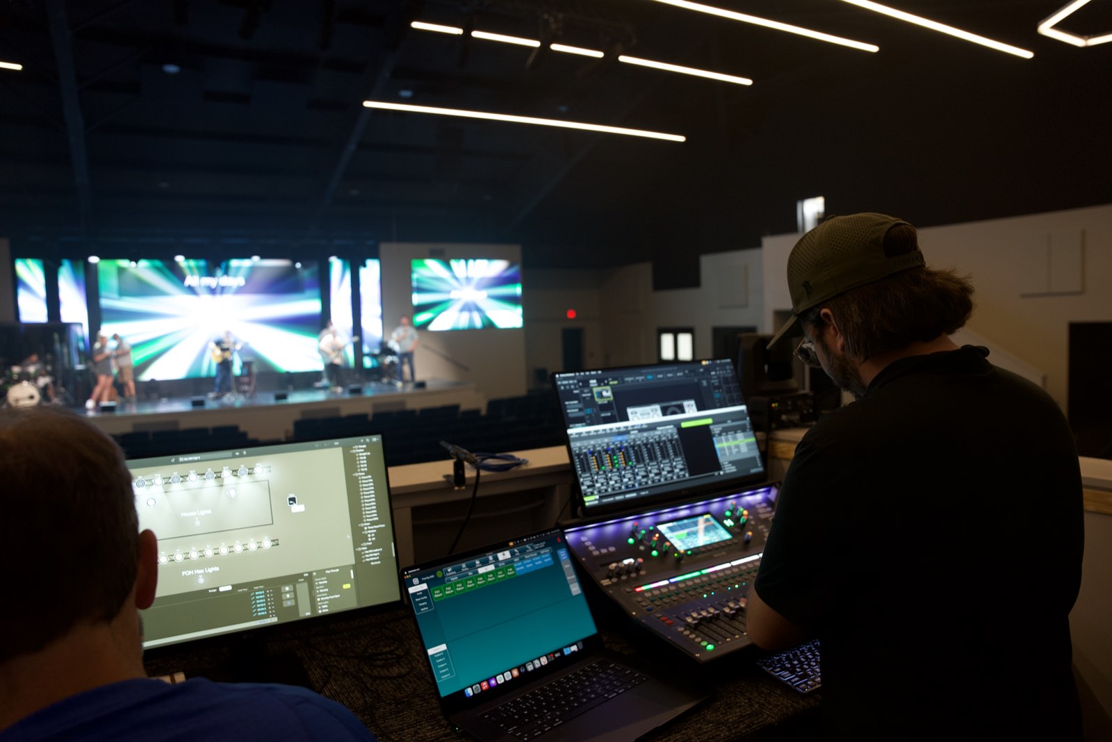 Engineers at the front of house mixing and lighting consoles at First Baptist Church Pontotoc, looking toward the lit stage