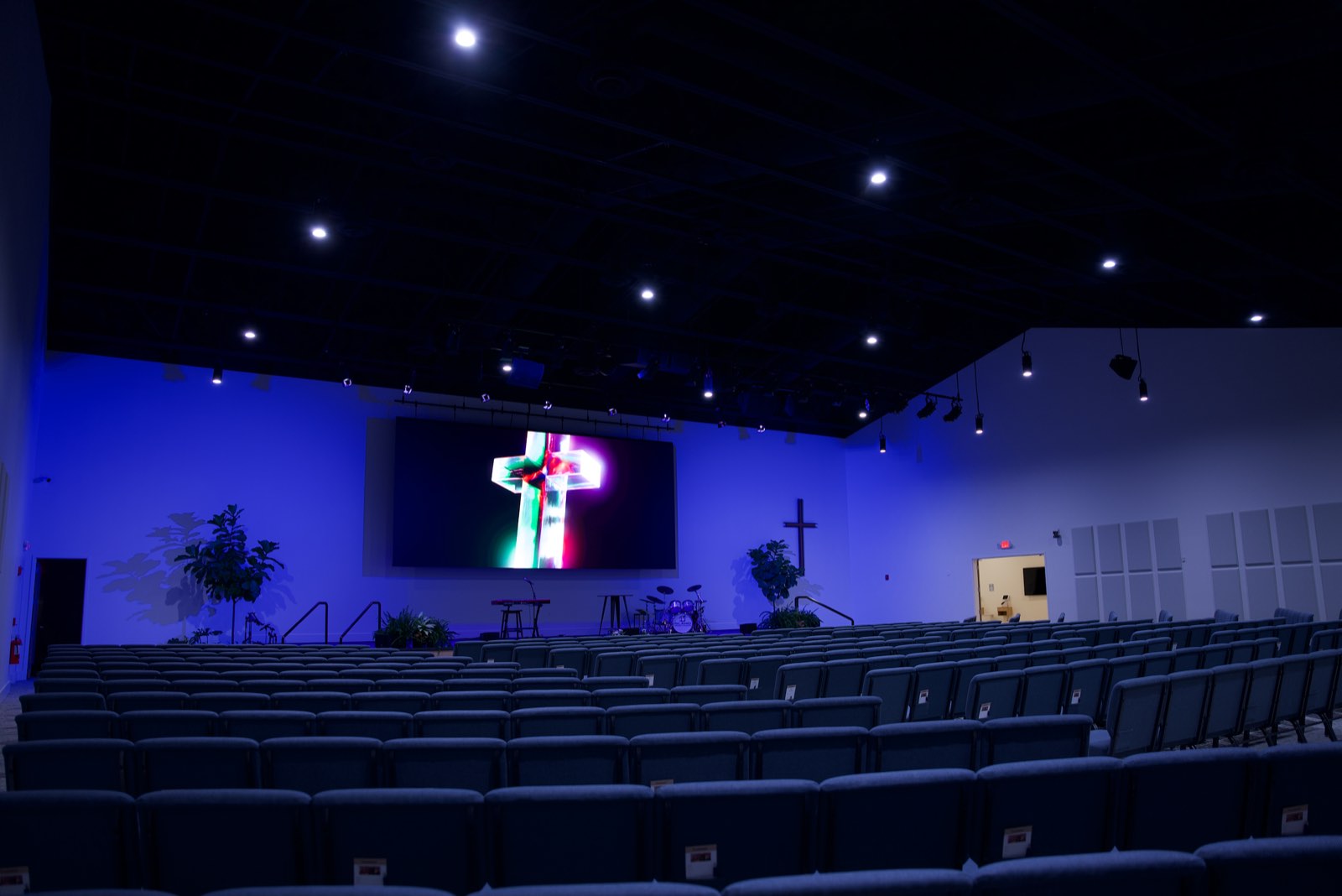 Island Community Church sanctuary with blue wall wash lighting and a cross graphic on the LED wall