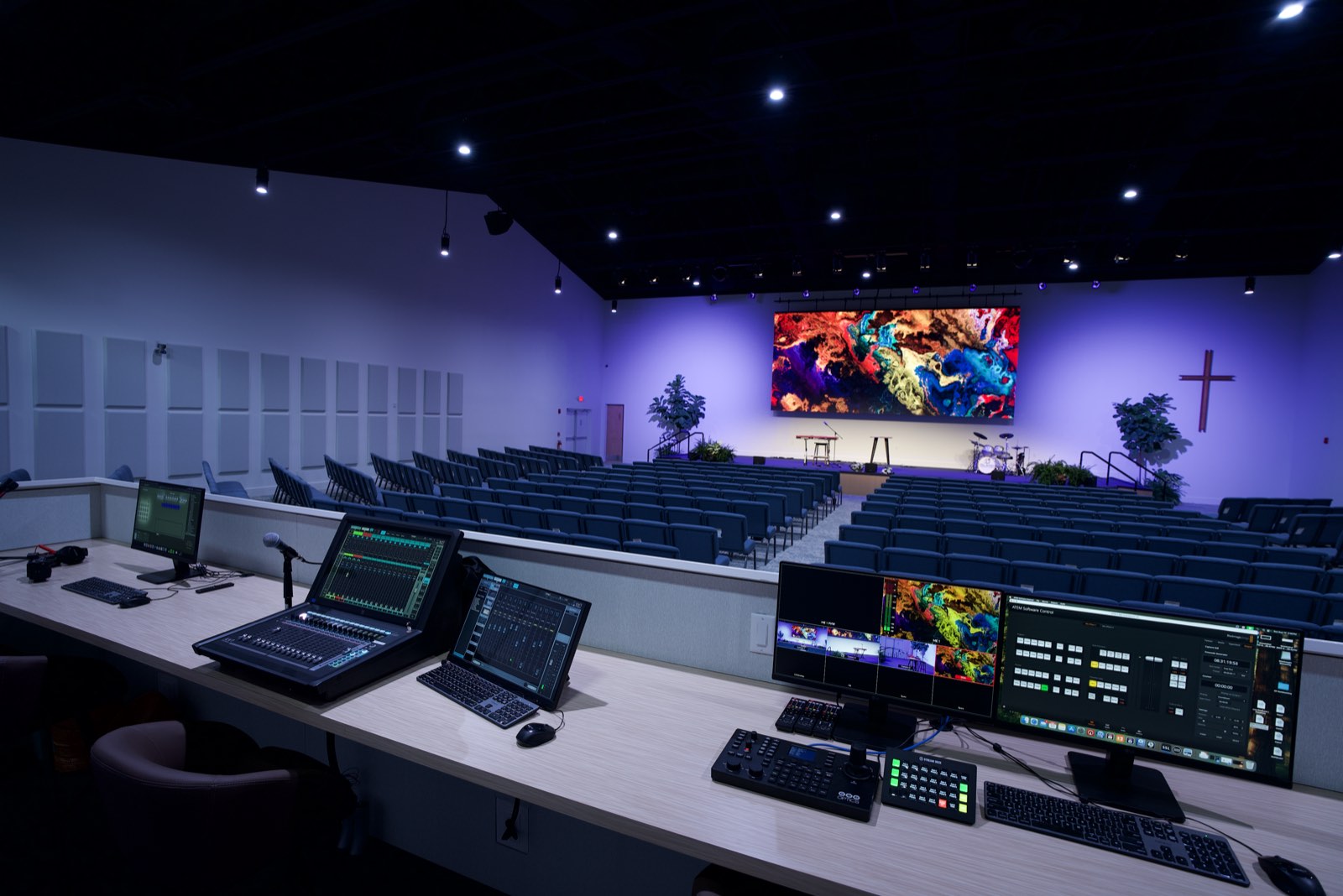 Production booth at Island Community Church with audio console, video switcher and streaming workstations facing the stage