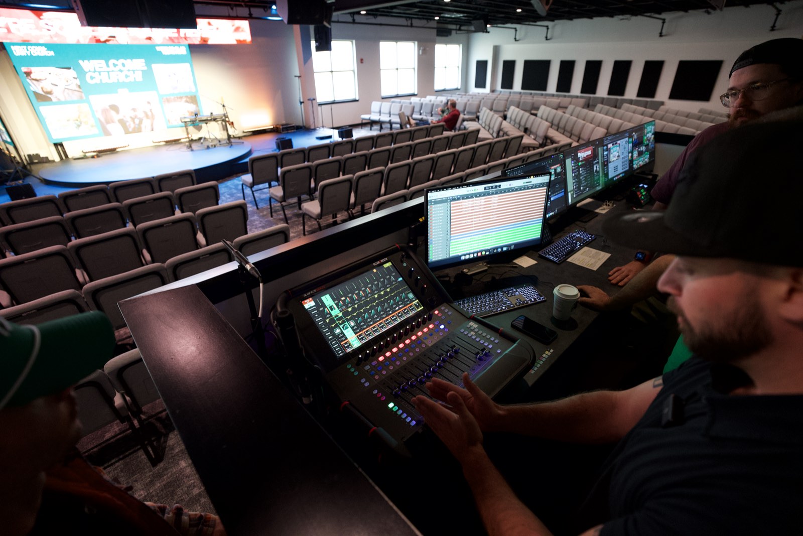 A church volunteer at the sound console before a Sunday service