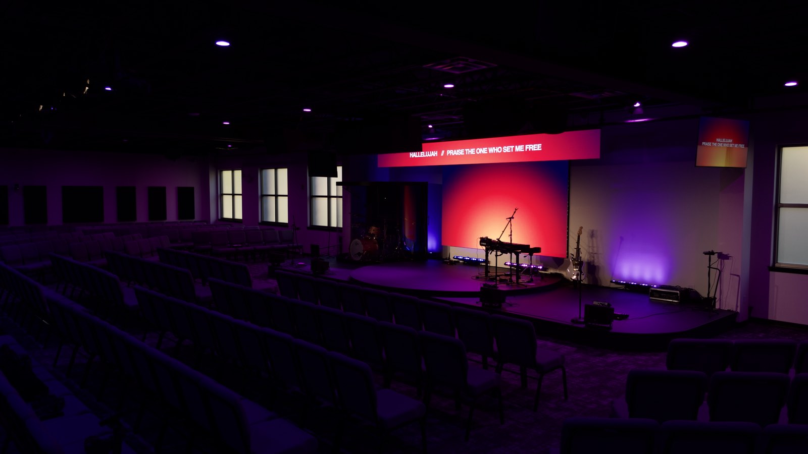 Next Community Church stage with warm and purple wall lighting framing the platform