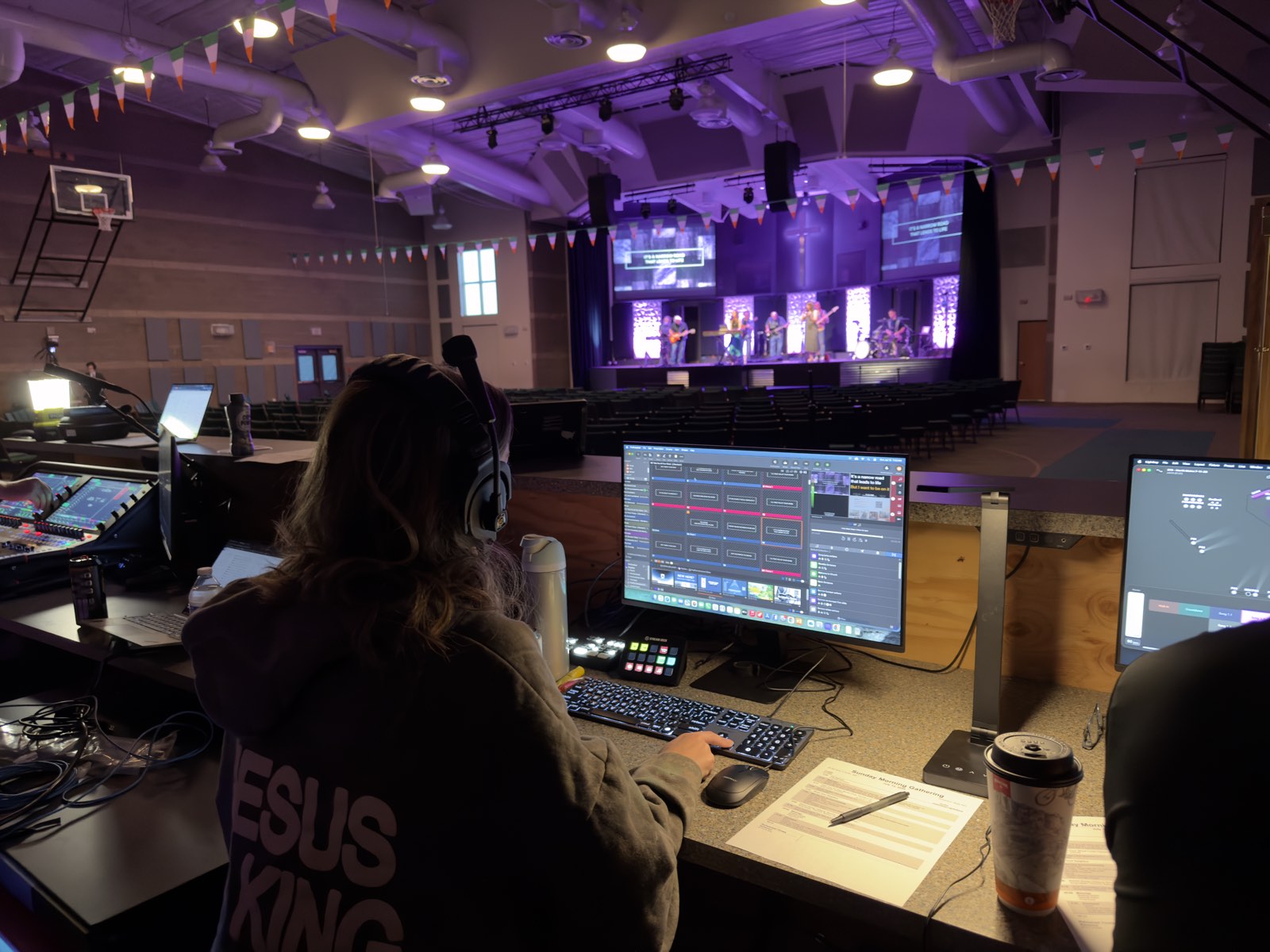 Volunteer running presentation and lighting from the front-of-house workstation at North Metro Church during worship