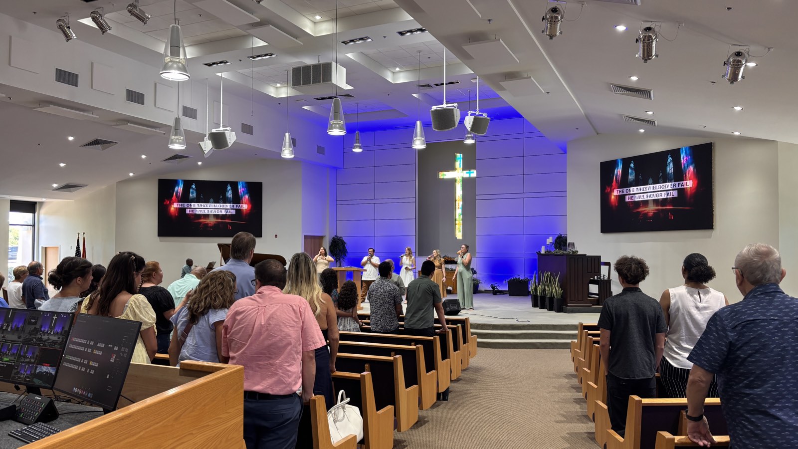 Thunderbird Seventh-day Adventist Church congregation in worship with LED screens on either side of the stained glass cross