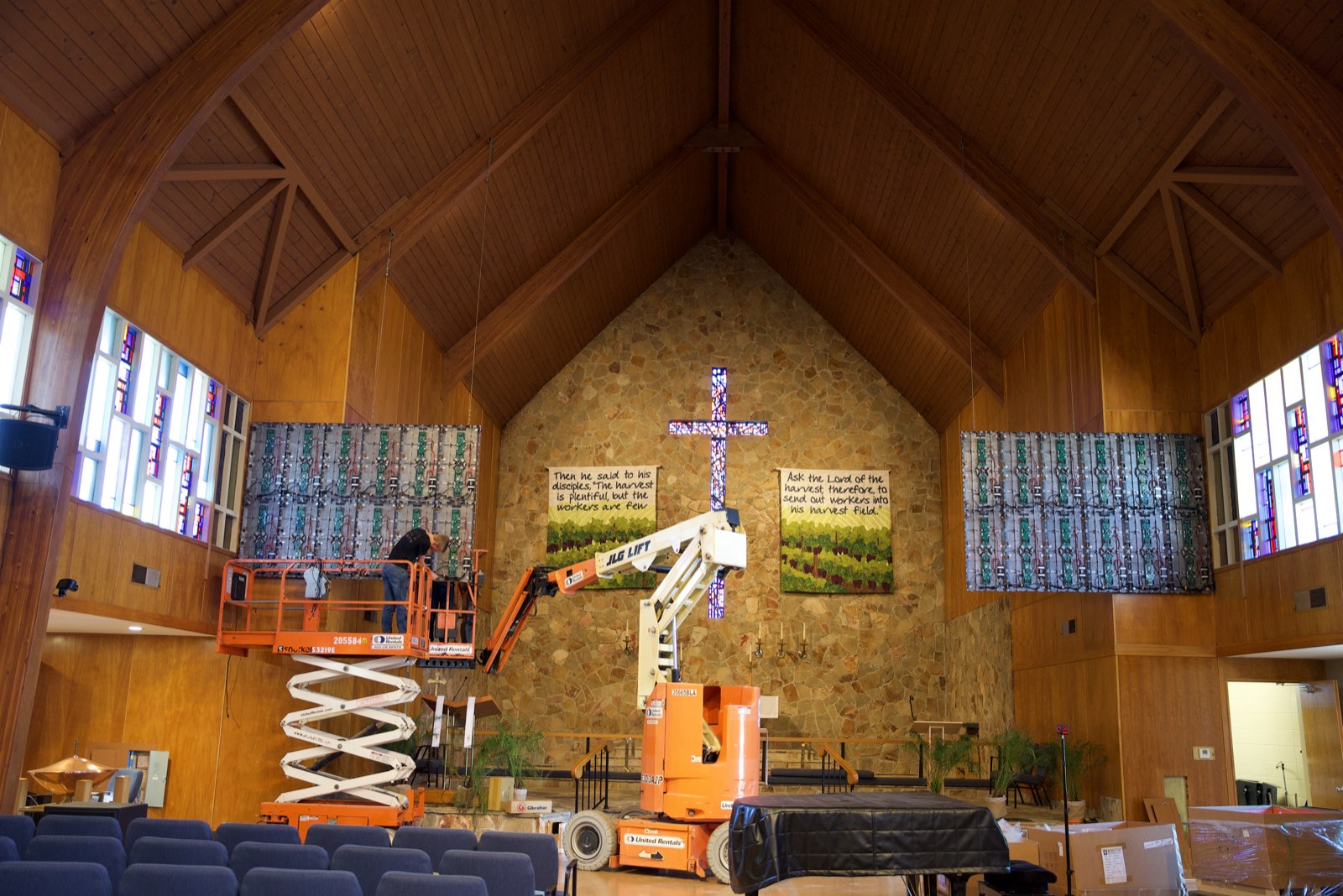 Crew on lifts installing two LED walls on either side of the cross in the chancel at St. John's Lutheran Church in Napa, California