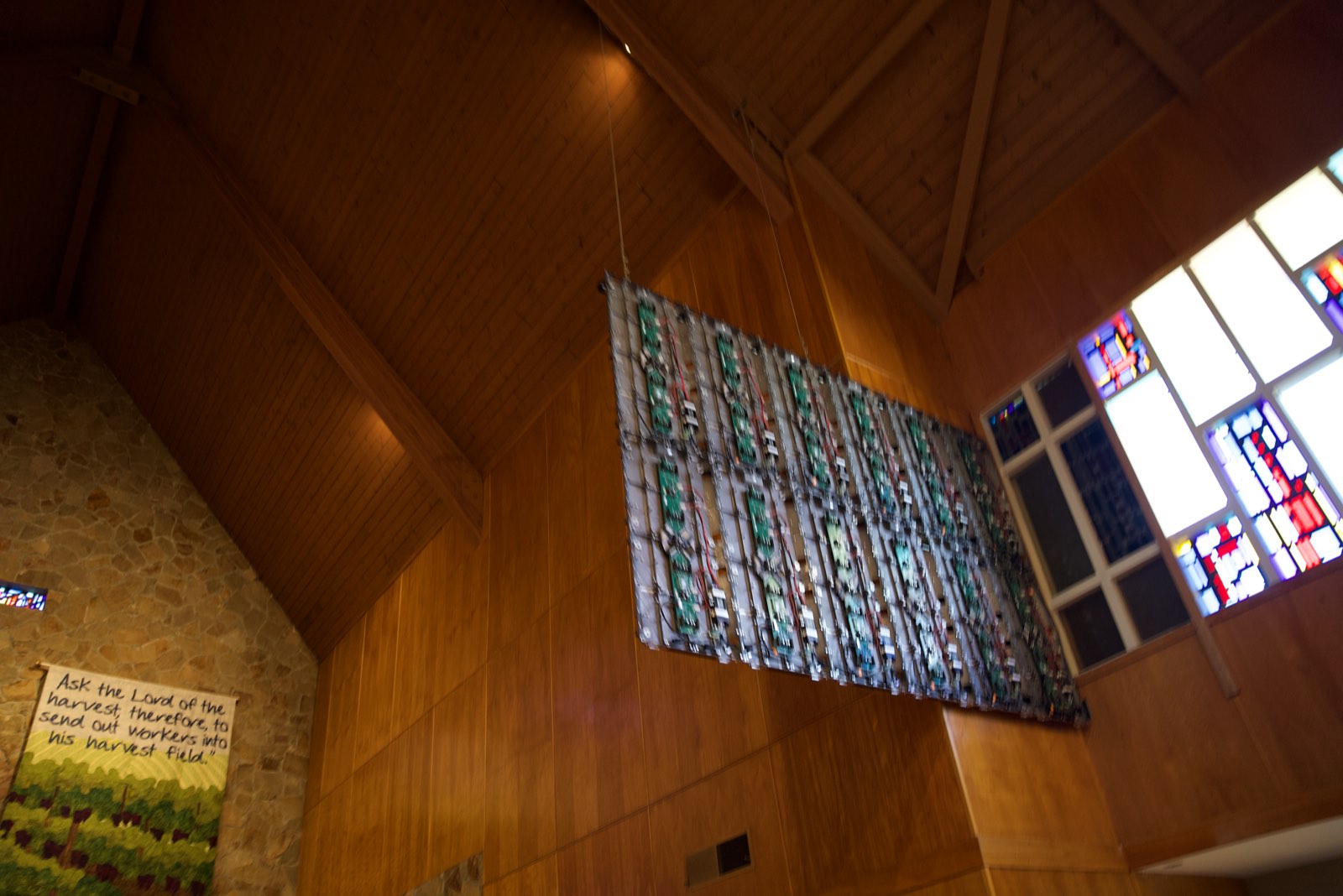 LED wall panels hung beside the stained glass windows during installation at St. John's Lutheran Church