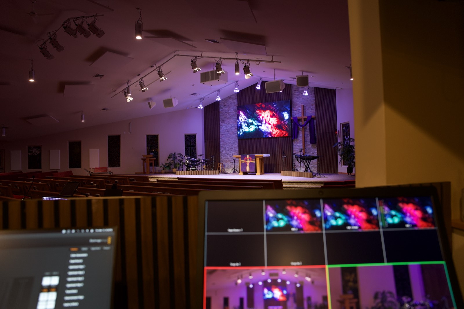 Video switcher multiview monitor in the foreground with the Trinity Church stage and LED wall beyond